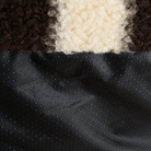 Nahaufnahme von gestreiftem Plüschstoff und gepunktetem schwarzen Material, Texturdetails.