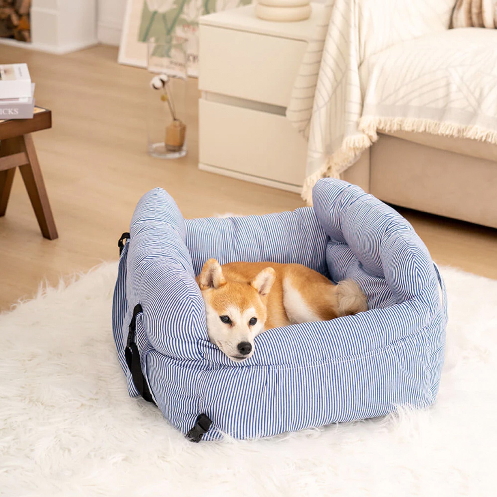Großes blau-weiß gestreiftes Hundebett, tragbar, für Auto und Zuhause, mit Hund auf Teppich.