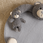 Graue Bären-Spielmatte aus Plüsch auf Teppich, ideal für Babys und Kleinkinder.