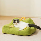 Katze auf grünem Plüsch-Monster-Design-Haustiersofa, gemütliches Tierbett, modernes Heimdekor.