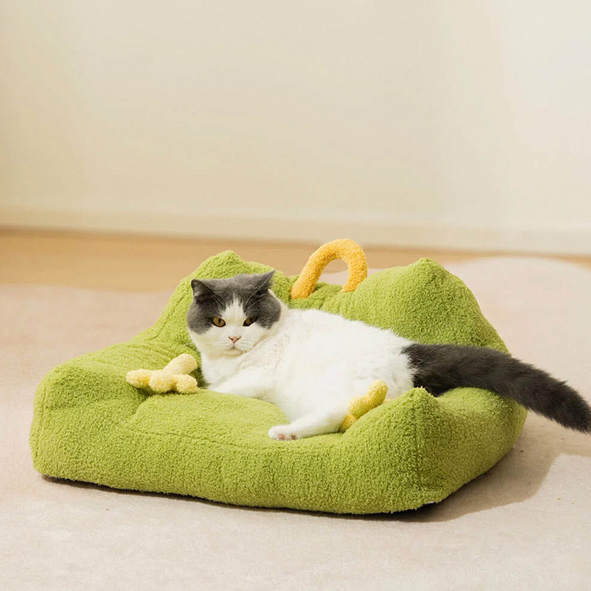 Katze auf grünem Plüsch-Monster-Design-Haustiersofa, gemütliches Tierbett, modernes Heimdekor.