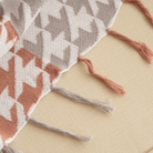 Strickdecke mit Zickzackmuster und Fransen, beige und rostfarben, gemütliche Sofadecke.