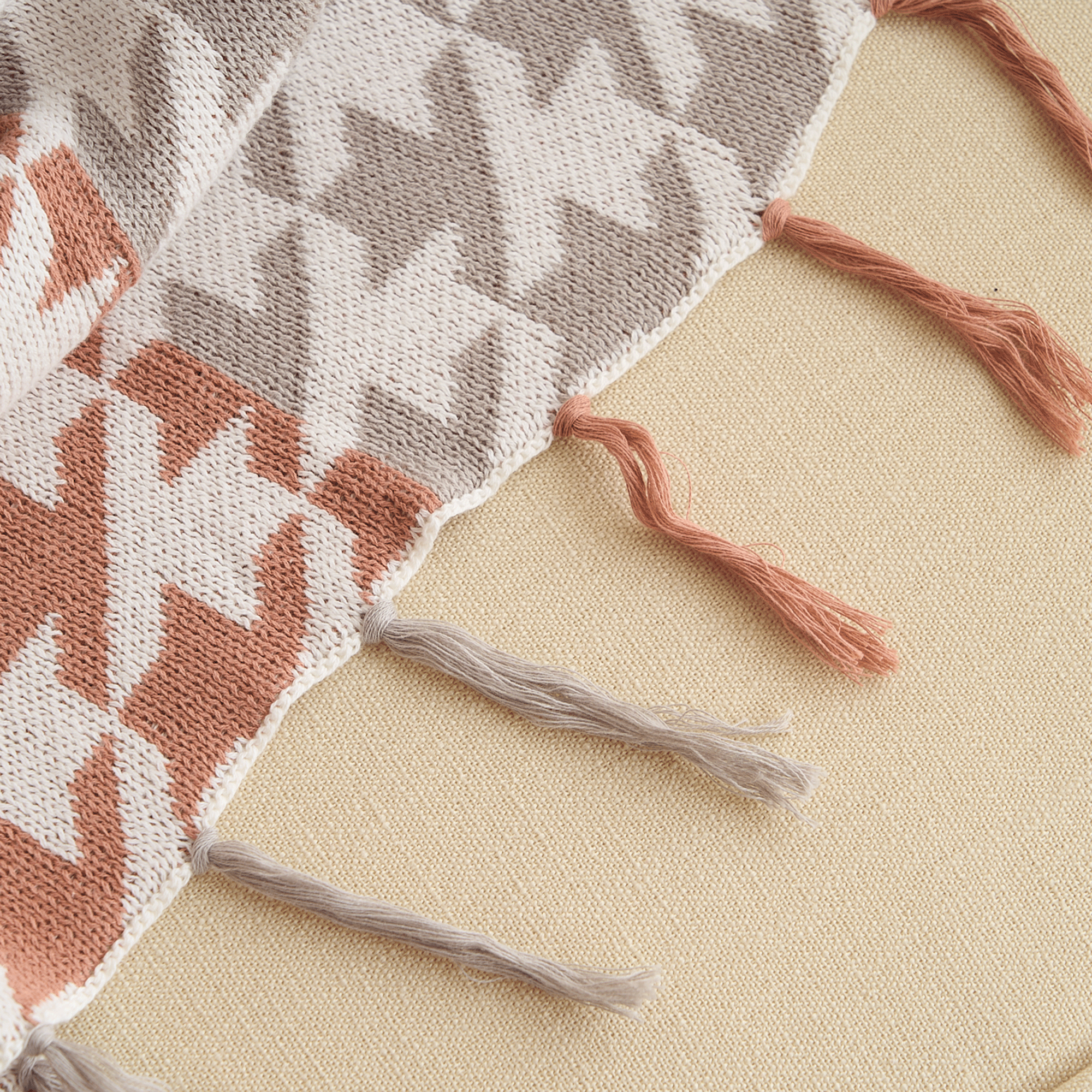 Strickdecke mit Zickzackmuster und Fransen, beige und rostfarben, gemütliche Sofadecke.