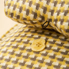 Nahaufnahme Waffelstruktur Hundebett, gelb-braun kariert, beruhigend, Knopfdetail.