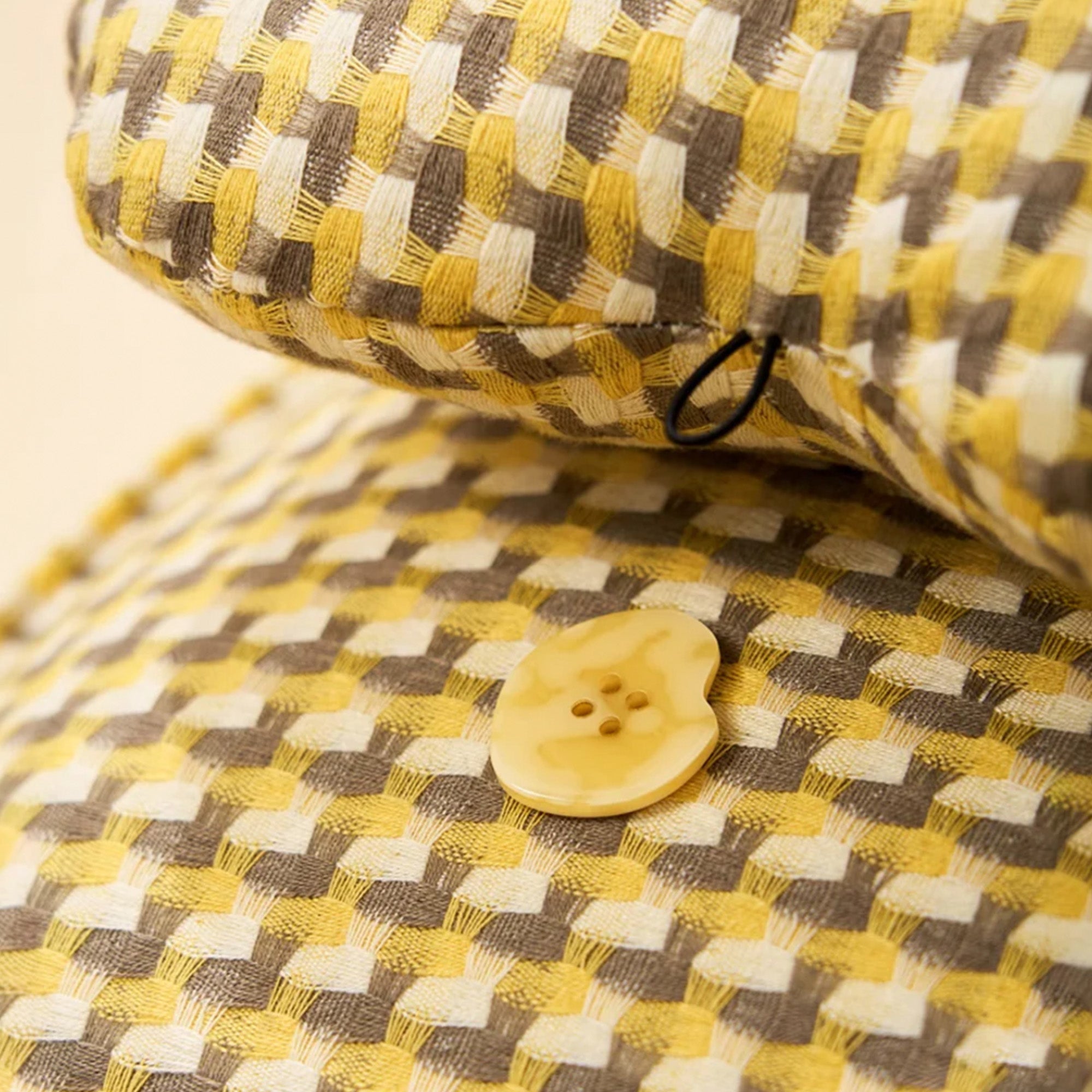 Nahaufnahme Waffelstruktur Hundebett, gelb-braun kariert, beruhigend, Knopfdetail.