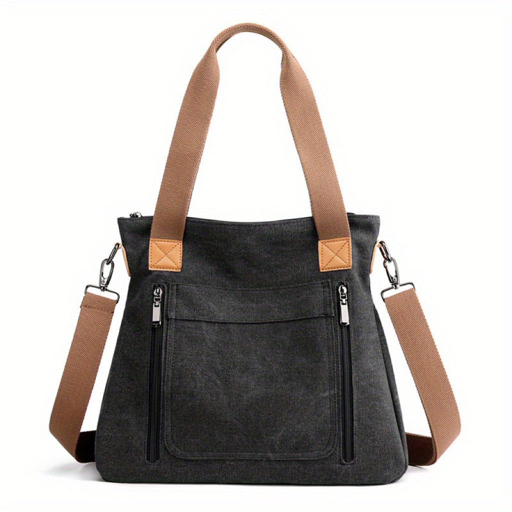 Stylische schwarze Canvas-Tasche mit braunen Trägern, Reißverschlusstaschen und abnehmbarem Schultergurt. Perfekt für Alltag und Reisen.