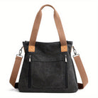 Stylische schwarze Canvas-Tasche mit braunen Trägern, Reißverschlusstaschen und abnehmbarem Schultergurt. Perfekt für Alltag und Reisen.