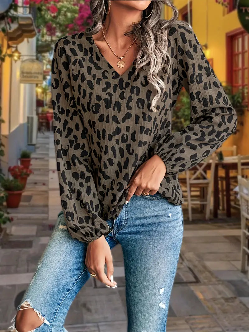 Damenbluse mit Leopardenmuster, V-Ausschnitt und langen Ärmeln, kombiniert mit zerrissenen Jeans. Modetrend, lässiger Stil, Streetwear.