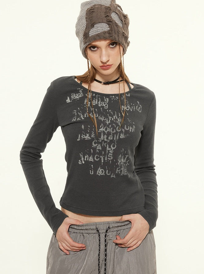 Damenmode: Graues Langarmshirt mit Schriftzug, kombiniert mit grauer Hose und gestrickter Mütze. Trendige Streetwear für Herbst/Winter.