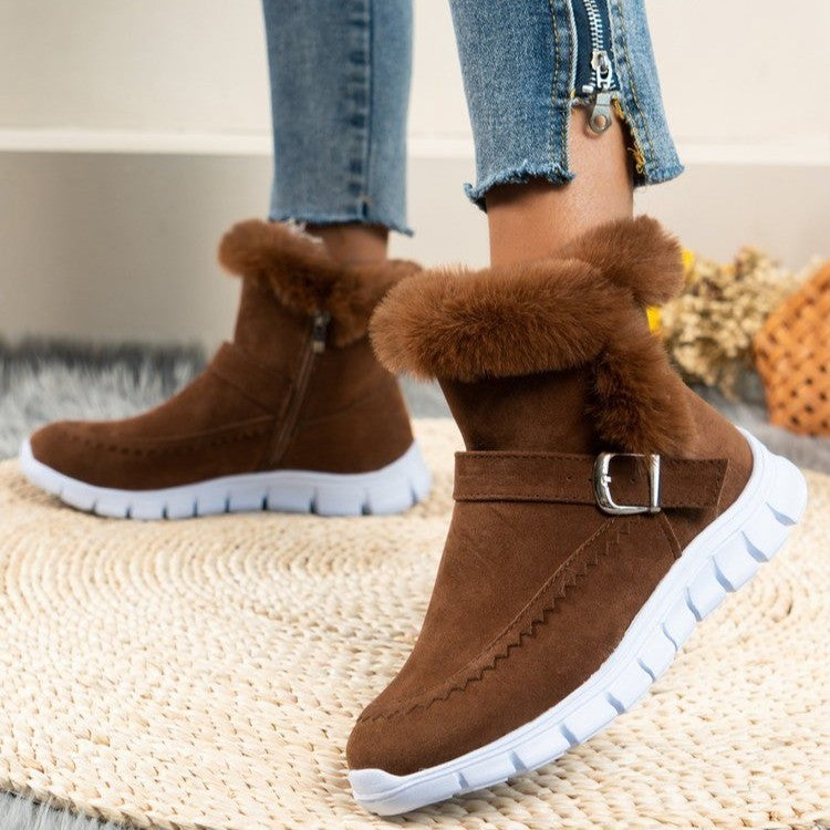 Damen-Winterstiefel aus braunem Wildleder mit Kunstfellfutter, Reißverschluss und Schnalle, kombiniert mit weißen Gummisohlen. Perfekt für kalte Tage.