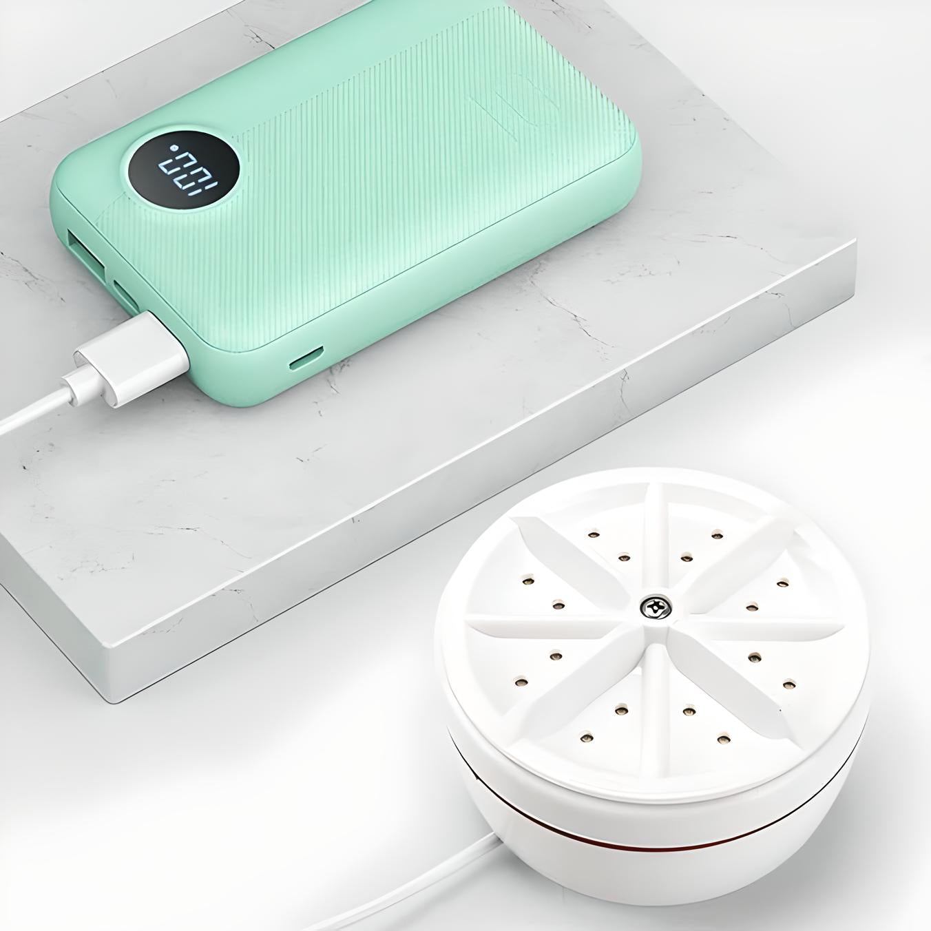 Mintgrüne Powerbank mit digitaler Anzeige und weißem Luftreiniger auf Marmorplatte.