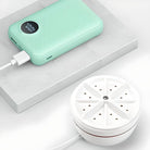 Mintgrüne Powerbank mit digitaler Anzeige und weißem Luftreiniger auf Marmorplatte.