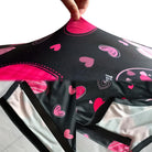 Schwarzer Stoff mit rosa Herzmustern, elastisch, für DIY-Projekte oder Bekleidung.
