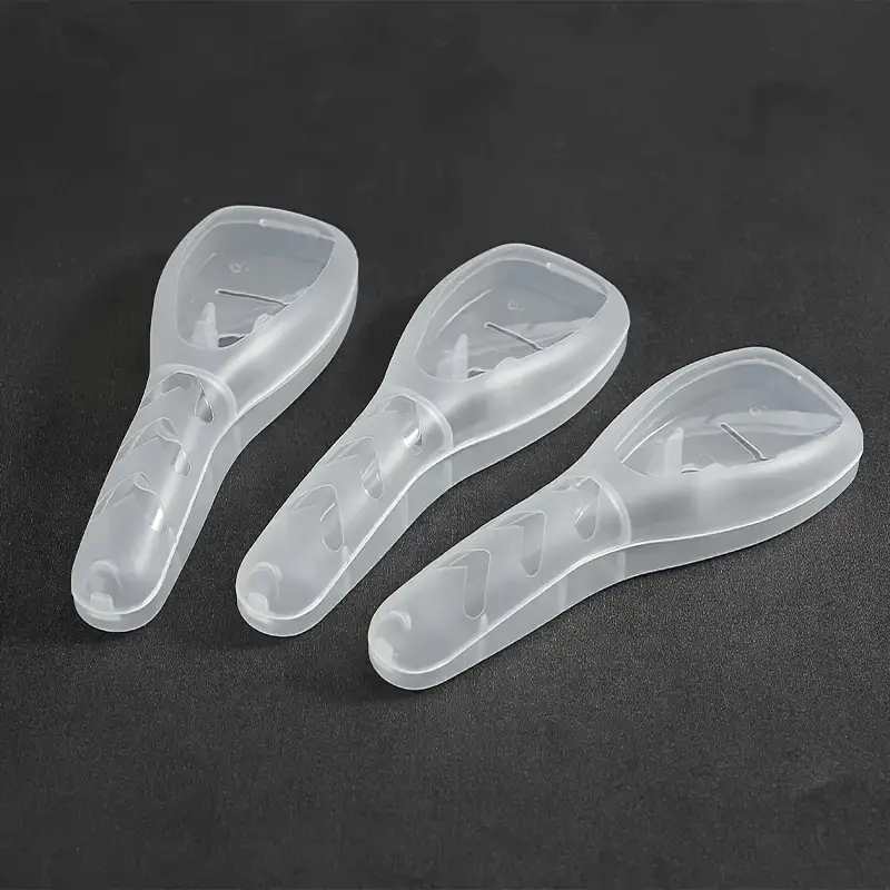 Drei transparente Kunststoffschäler auf schwarzem Hintergrund, Küchengerät, ergonomisches Design.