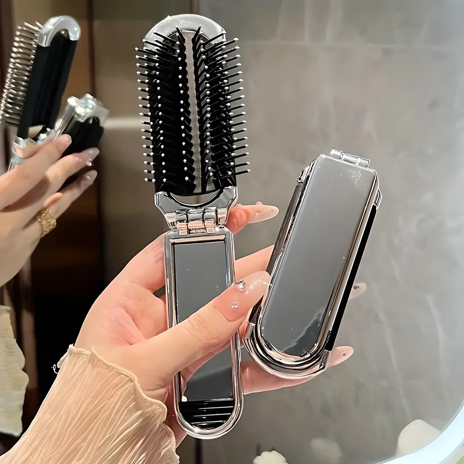 Faltbare Haarbürste mit Spiegel, schwarz-silber, tragbar, ideal für unterwegs, stilvolles Design.