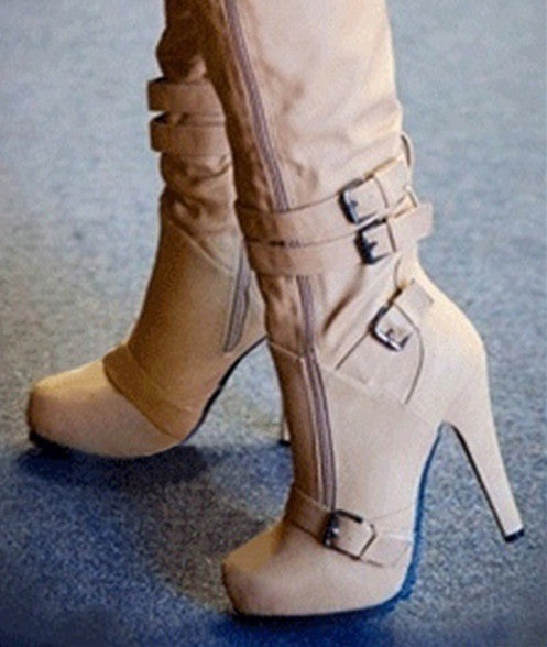 Beige Stiefel mit hohen Absätzen, Schnallen und Reißverschluss auf blauem Teppich. Modische Damenstiefel, elegant und trendig.
