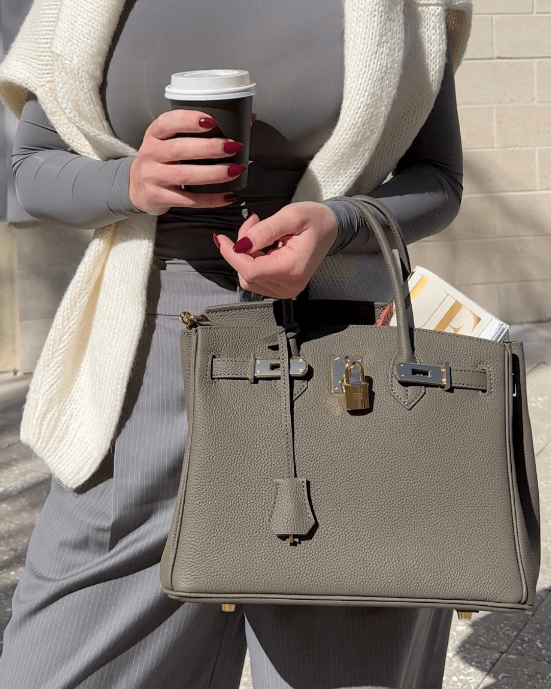 Frau mit grauer Lederhandtasche und Kaffeebecher, modisch, elegant, Accessoire, Herbstmode.