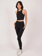 Frau in schwarzem Sport-BH und Leggings, ideal für Yoga und Fitness. Bequeme, atmungsaktive Sportbekleidung für aktive Frauen.