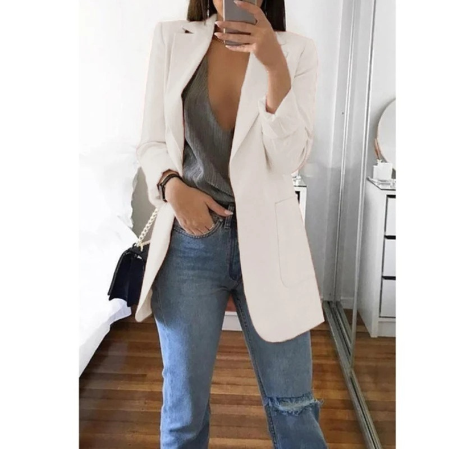 Eleganter weißer Blazer für Damen, kombiniert mit grauem Top und blauen Jeans. Perfekt für stilvolle Business- und Freizeitlooks.