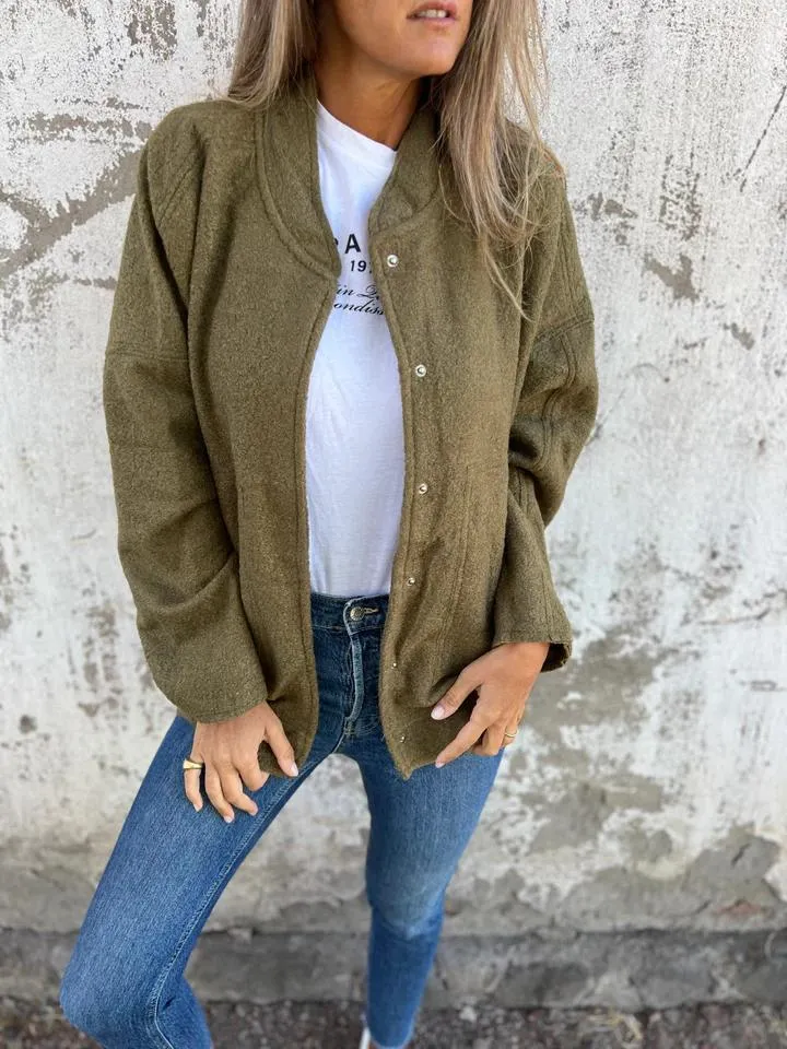 Damenmode: Lässige olivgrüne Strickjacke über weißem T-Shirt, kombiniert mit blauen Jeans. Perfekt für Herbst-Outfits und Streetstyle.