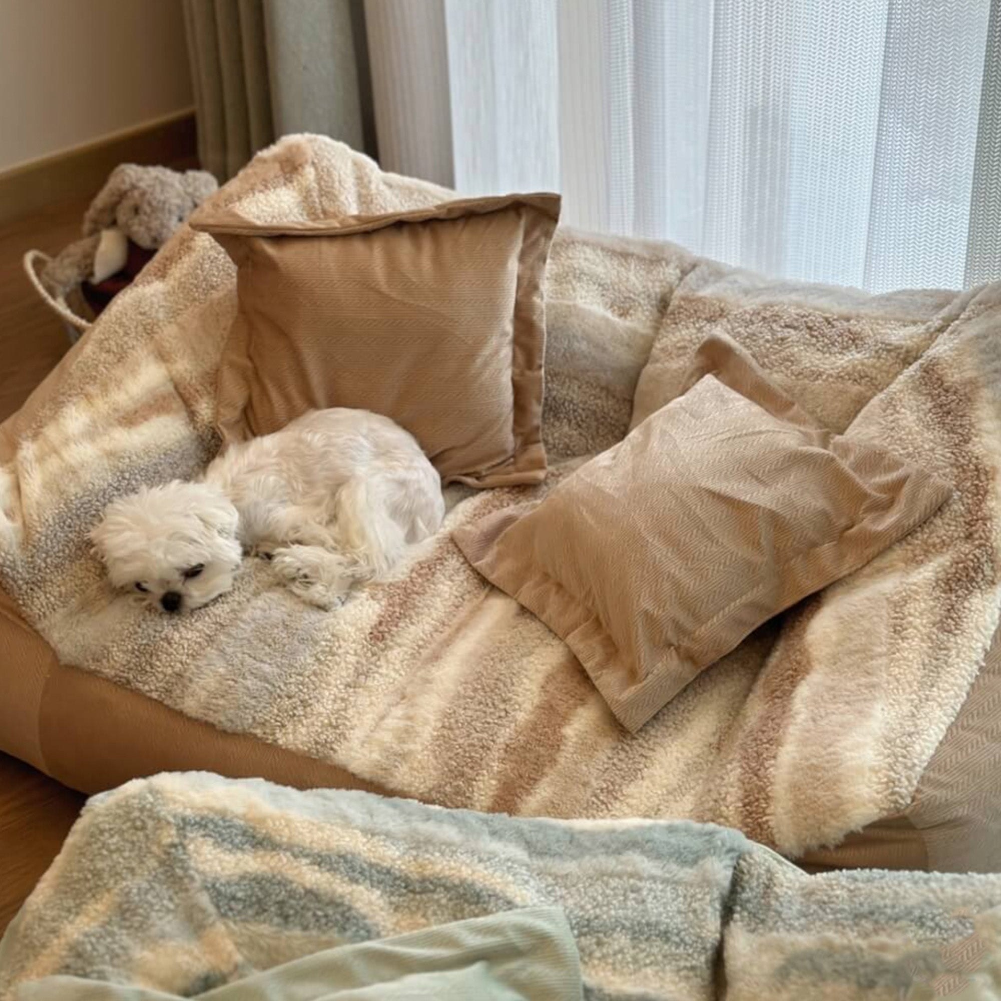 Weißer Hund auf beige-weißem Polar-Fleece-Hundebett mit Kissen, gemütlich und stilvoll.