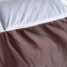 Katzenbett aus braunem Stoff mit weißen Punkten, weiche Polsterung, gemütliches Haustierbett.