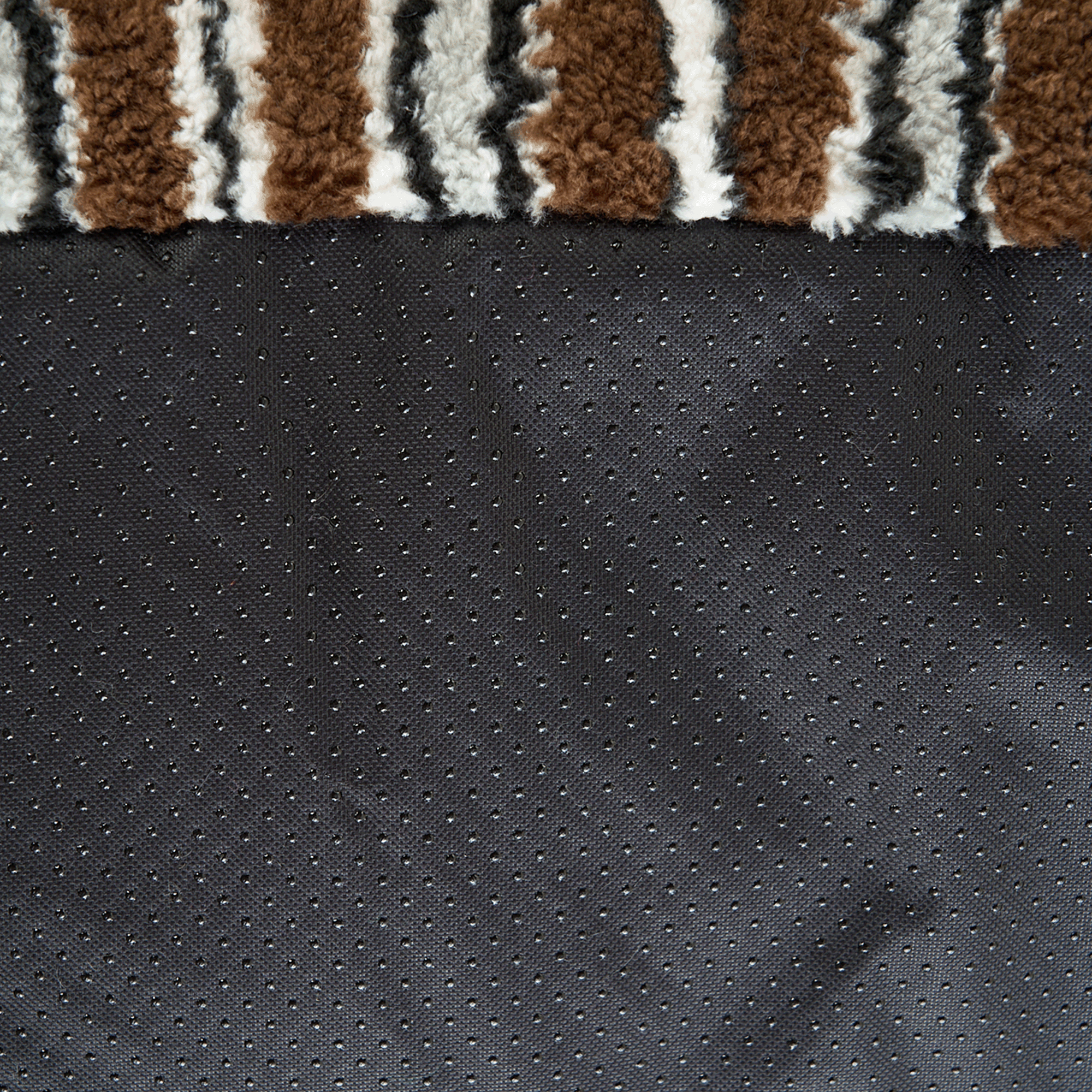 Nahaufnahme gestreiftes Haustiersofa mit Kissen, monochrom, braun-schwarz, weiches Material.