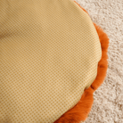 Runde Schlafmatte, beige mit orangefarbenem Rand, weiches Material, ideal für Haustiere.