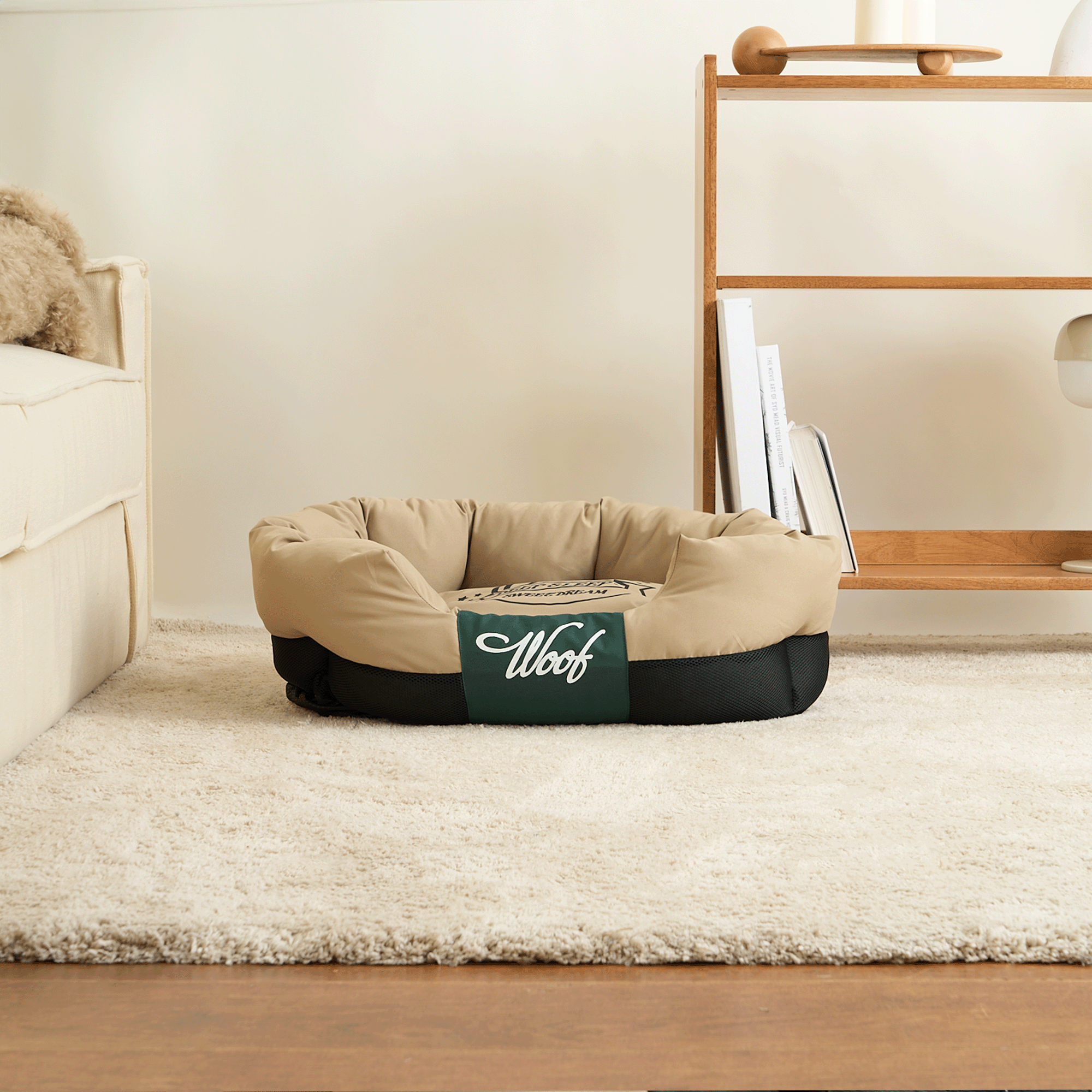 Wasserfestes Hundebett, beige und schwarz, auf Teppich im Wohnzimmer, ideal für Haustiere.