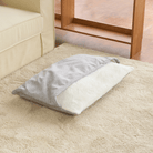 Ultraweicher Haustier-Schlafsack, grau-weiß, flauschig, gemütlich, auf Teppich neben Sofa.