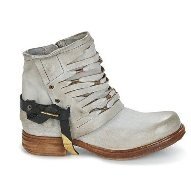 Damenstiefelette aus Leder in Beige mit Holzabsatz und dekorativen Riemen. Modische, bequeme Schuhe für Herbst und Winter. Vintage-Look.
