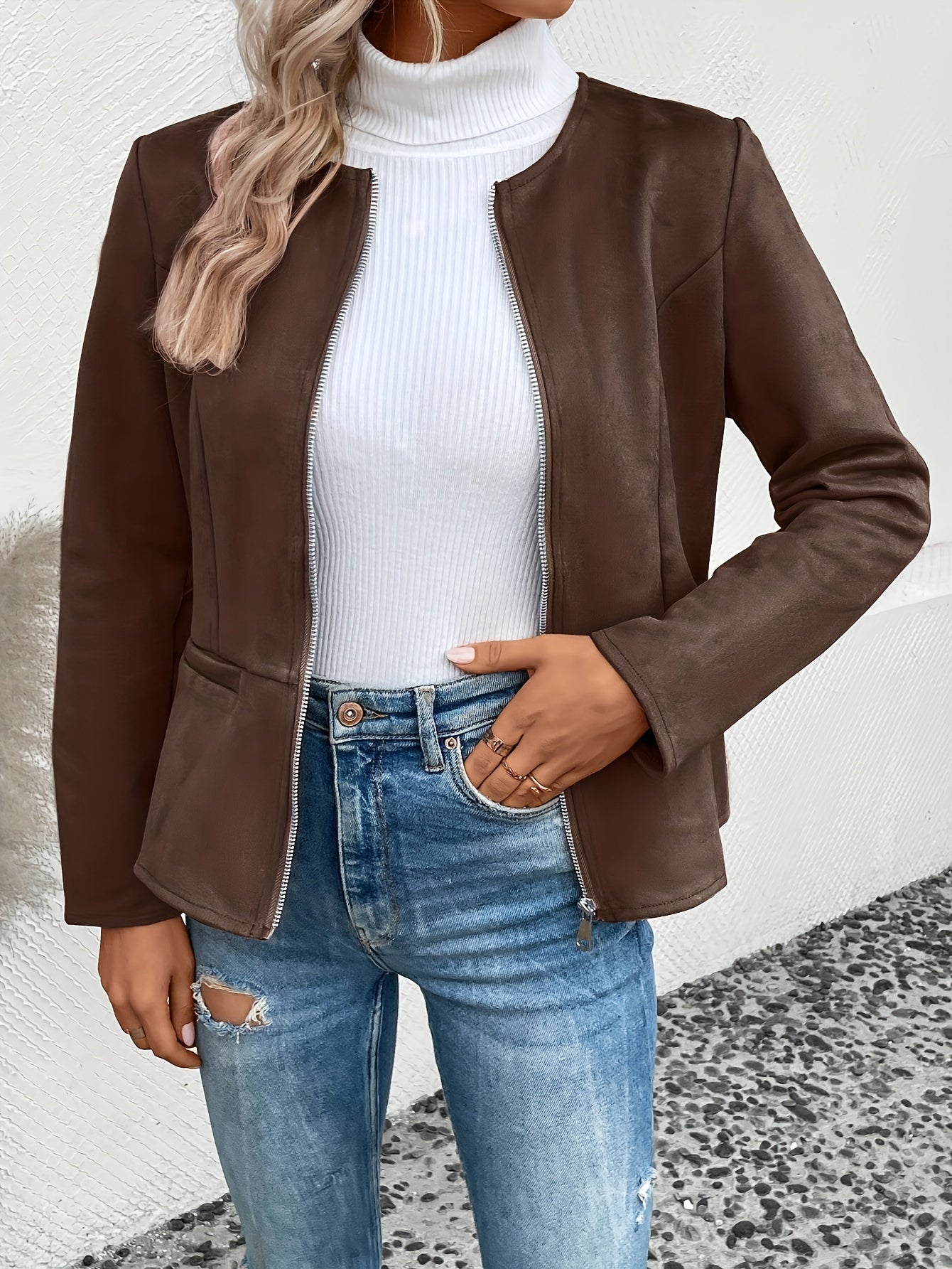 Damen-Lederjacke in Braun, kombiniert mit weißem Rollkragenpullover und zerrissenen Jeans. Modetrend, stilvoll, lässig, Herbstmode.