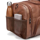 Braune Ledertasche mit Netzseitentasche, enthält Trinkflasche und graues Etui.