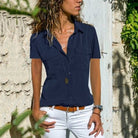 Frau in dunkelblauer Bluse und weißer Hose, lässiger Sommerlook, draußen, modisch.