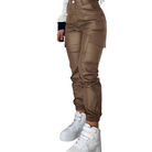 Damen-Cargohose in Braun, hoher Bund, seitliche Taschen, kombiniert mit weißen Sneakern. Modische Streetwear für trendbewusste Frauen.