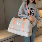 Damen Reisetasche beige, rosa Träger, geräumig, modisch, ideal für Wochenendausflüge.