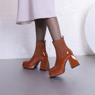 Damenstiefeletten in glänzendem Braun mit Blockabsatz und gerippter Knöchelpartie. Modische, elegante Schuhe für Herbst und Winter.