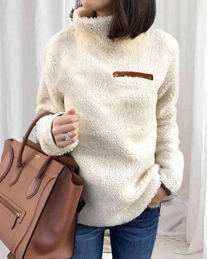 Damen Teddy-Fleece-Pullover in Weiß, kombiniert mit brauner Lederhandtasche. Modischer, kuscheliger Look für Herbst und Winter.