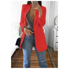 Frau in rotem Blazer, grauem Top und blauen Jeans posiert im Schlafzimmer. Modetrend, stilvolle Damenbekleidung, lässiger Chic.