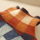 Buntes Strickmuster mit Karodesign in warmen Tönen. Perfekt für modische Herbst- und Winterkleidung. Hochwertige Wolle, stilvoll und gemütlich.