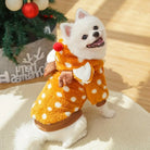 Niedlicher Hund im Rentier-Kostüm mit Punkten, lächelnd vor Weihnachtsbaum. Perfekt für festliche Haustiermode, Winterkleidung, Hundepullover.