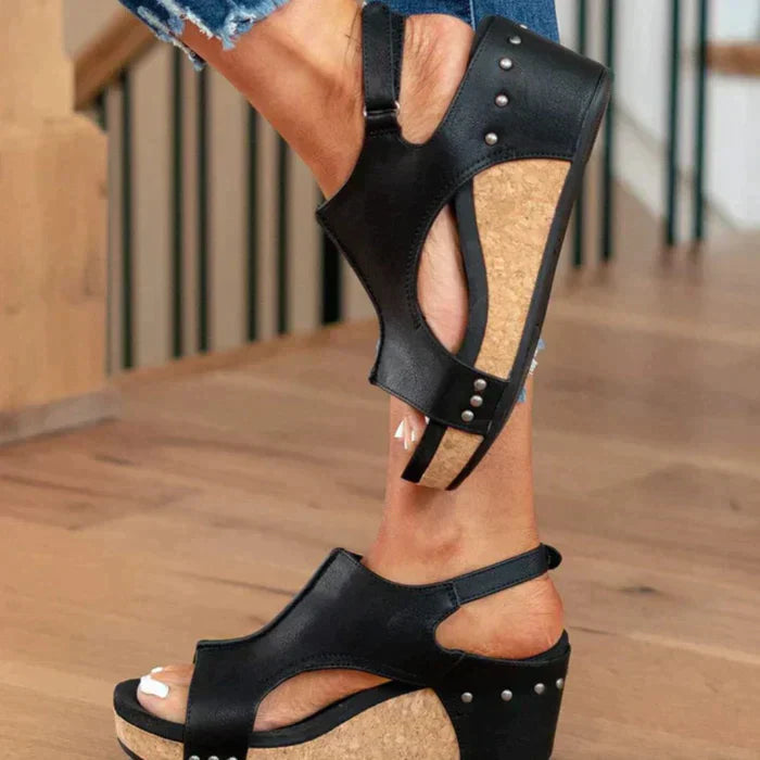 Schwarze Keilsandalen mit Korksohle und Nieten, ideal für Sommermode. Bequeme Damen-Schuhe, perfekt für lässige Outfits und trendige Looks.