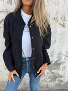Damenmode: Schwarze Strickjacke, lässig über weißem T-Shirt und blauer Jeans getragen. Trendige Herbstmode, stilvoll und bequem.
