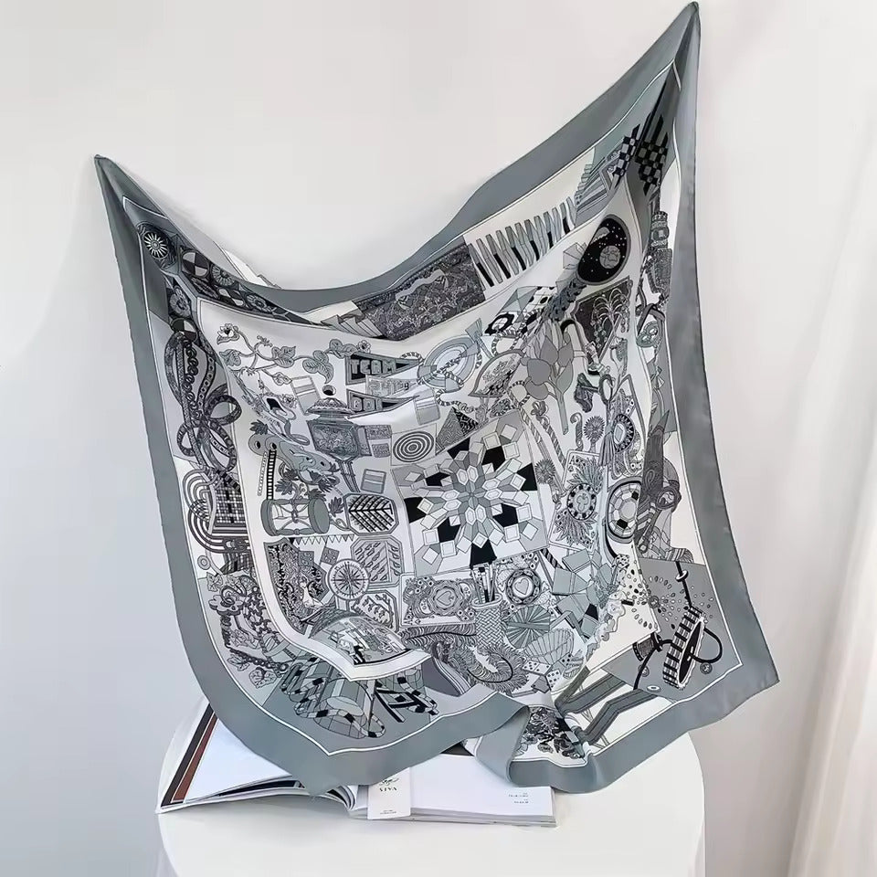 Graues Seidentuch mit geometrischem Muster, dekorativ drapiert, luxuriöses Accessoire.