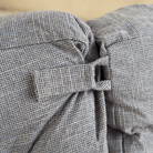 Graues, strukturiertes Haustierbett aus Stoff mit dekorativer Schleife, modernes Design.