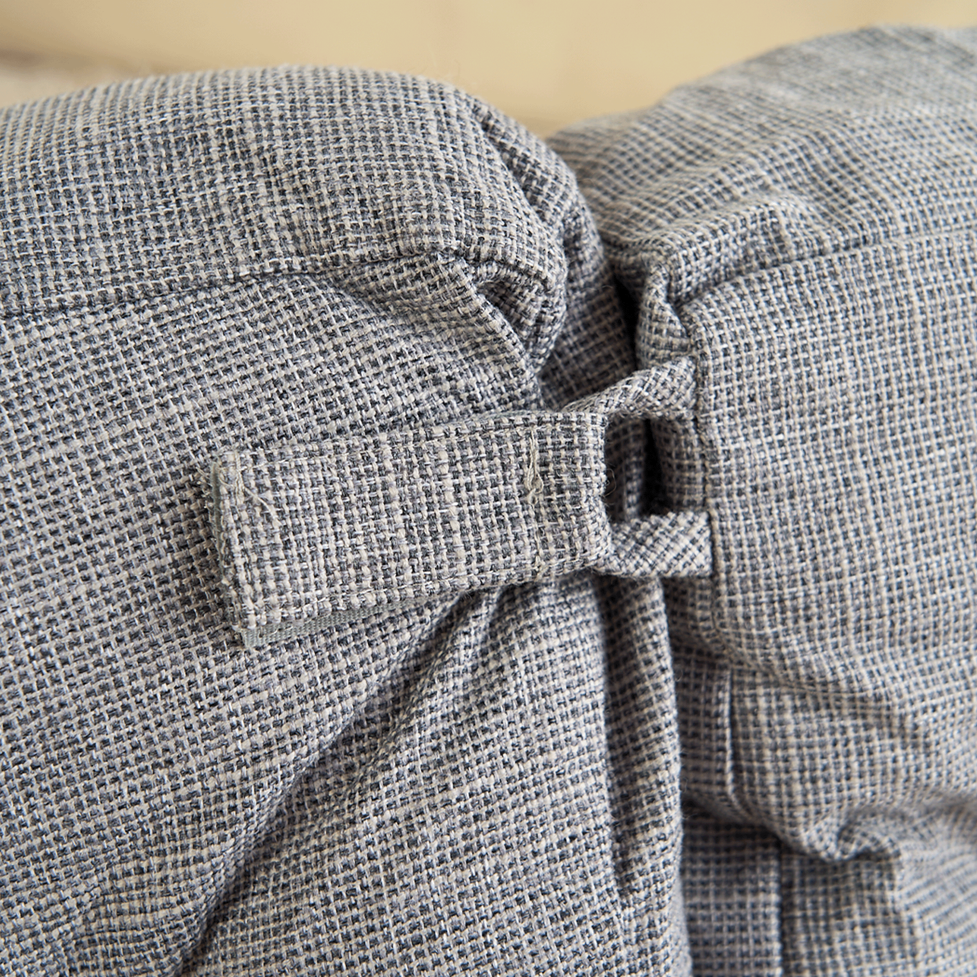 Graues, strukturiertes Haustierbett aus Stoff mit dekorativer Schleife, modernes Design.