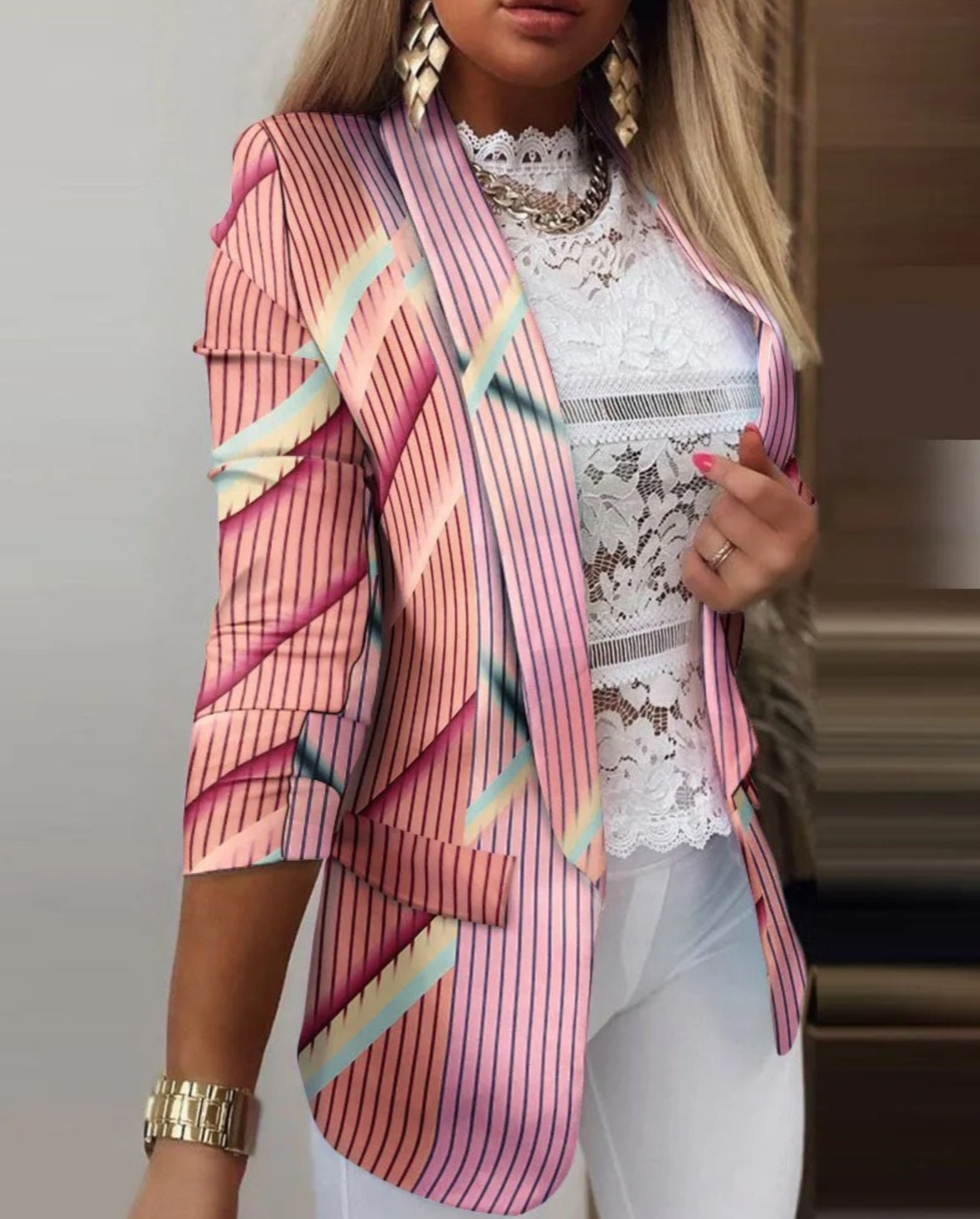 Damenblazer mit rosa Streifenmuster, kombiniert mit weißer Spitzenbluse und goldenen Accessoires. Modetrend, eleganter Look, stilvolle Kleidung.