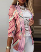 Damenblazer mit rosa Streifenmuster, kombiniert mit weißer Spitzenbluse und goldenen Accessoires. Modetrend, eleganter Look, stilvolle Kleidung.