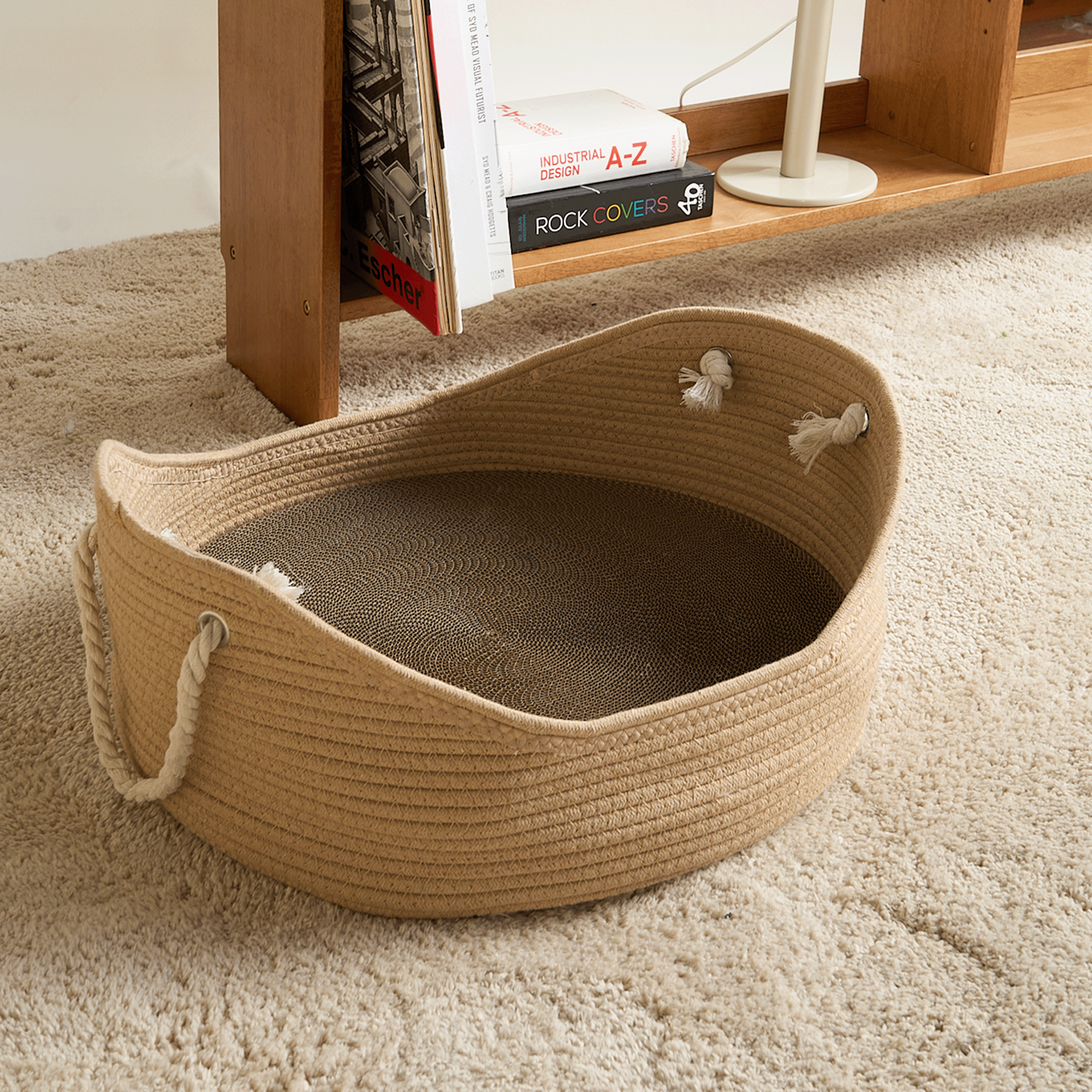 Handgefertigtes Katzenbett aus Weidengeflecht, beige, mit Seilgriffen auf Teppichboden.