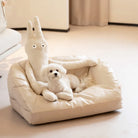 Kühlendes Leder-Haustiersofa in Beige mit Plüschspielzeug und kleinem weißen Hund.